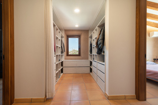 Spacious and bright walk-in closet with window.